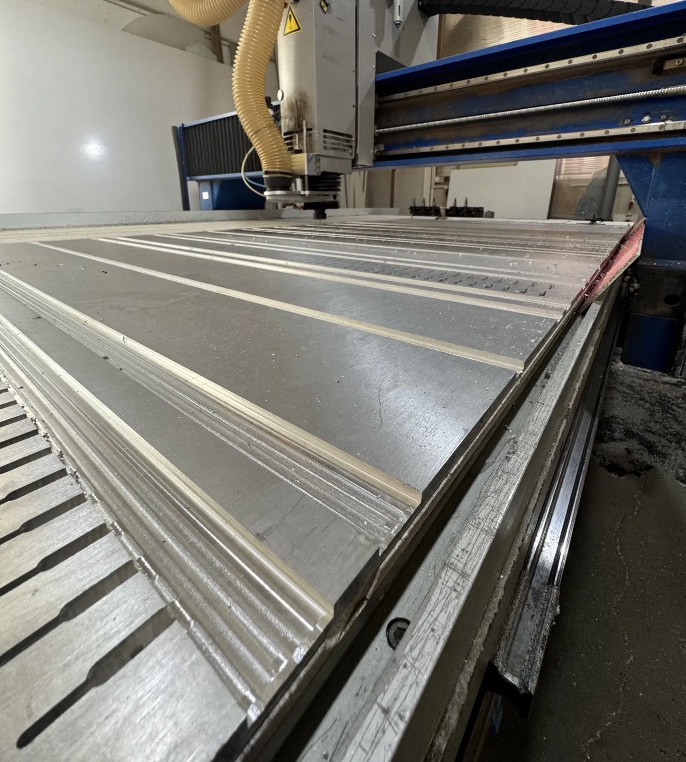 Routerul CNC din atelier în timpul prelucrării unui panou